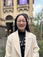 A person stands in front of Melbourne Town Hall.