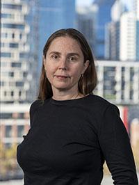 Woman dressed in black with cityscape in background