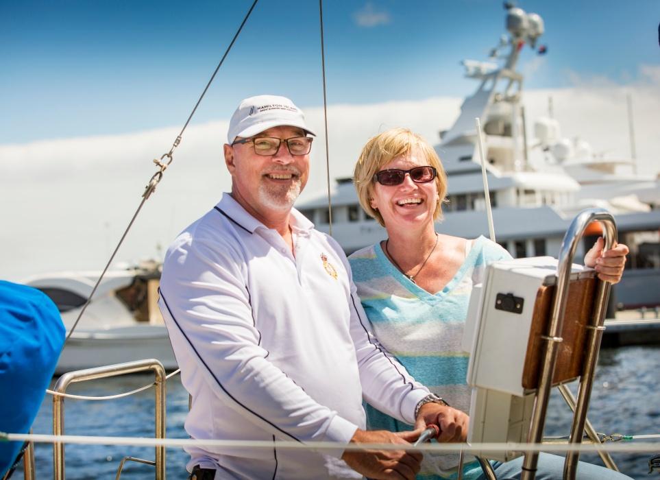 Smiling couple at the wheel of their boat