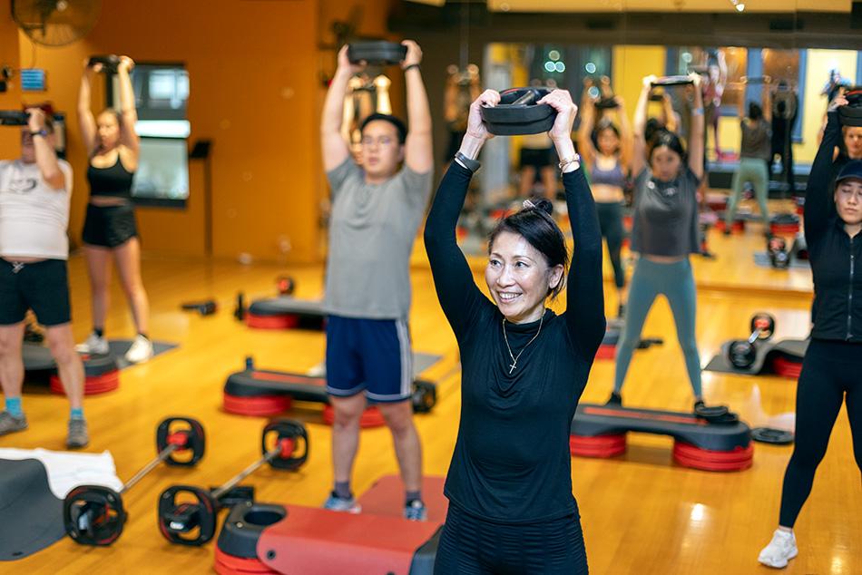 People lifting weights in a group fitness class.