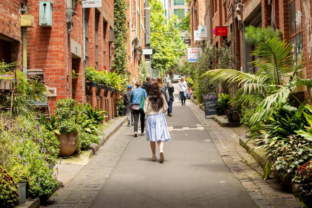 Pedestrians walking through Guildford lane surrounded by verdant greenery