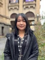 A person stands in front of Melbourne Town Hall.