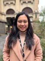A person stands in front of Melbourne Town Hall.