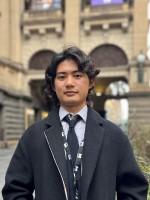 A person stands in front of Melbourne Town Hall.
