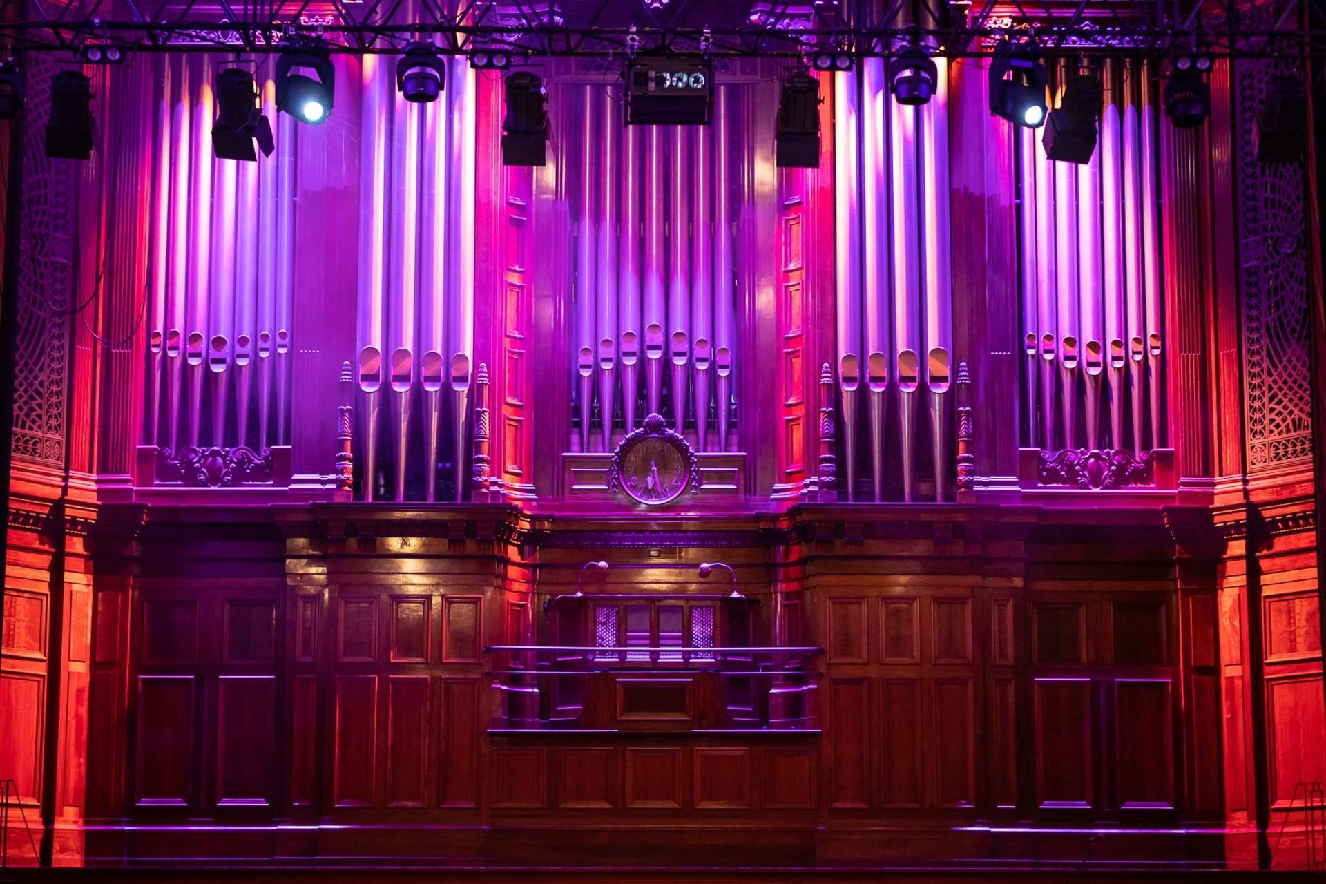 Historic organ with pipes lit in purple
