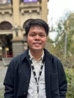 A person stands in front of Melbourne Town Hall.