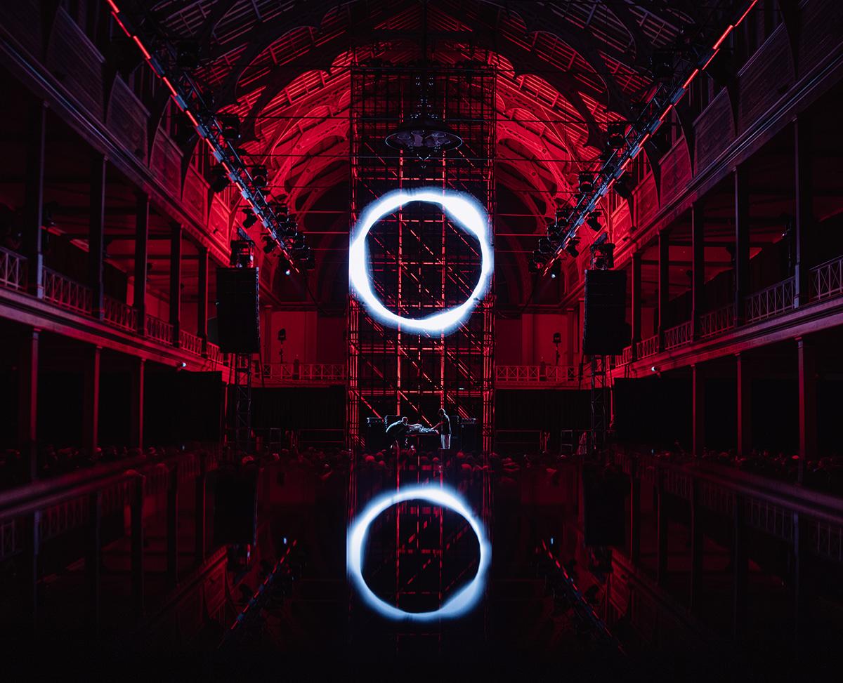 Interior of darkened concert space with dramatic lighting.