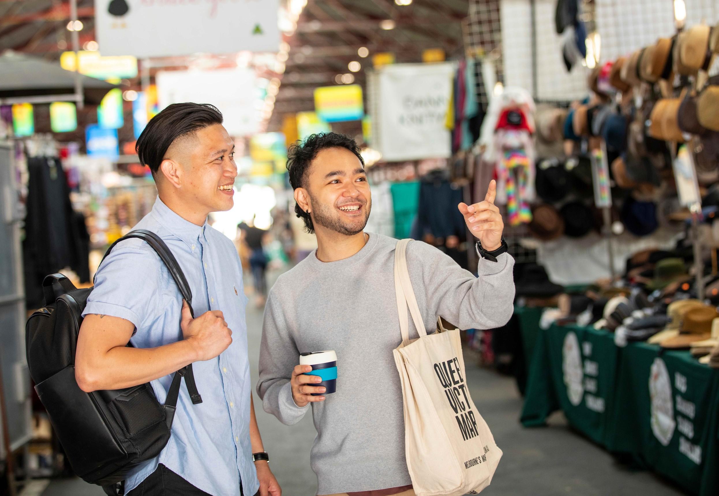 Two people shopping at Queen Victoria Market.