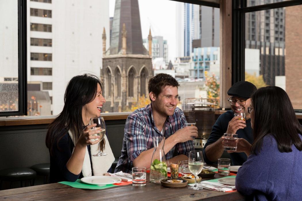 Group of people enjoying drinks at a rooftop restaurant