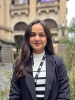 A person stands in front of Melbourne Town Hall.