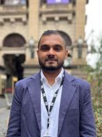 A person stands in front of Melbourne Town Hall.