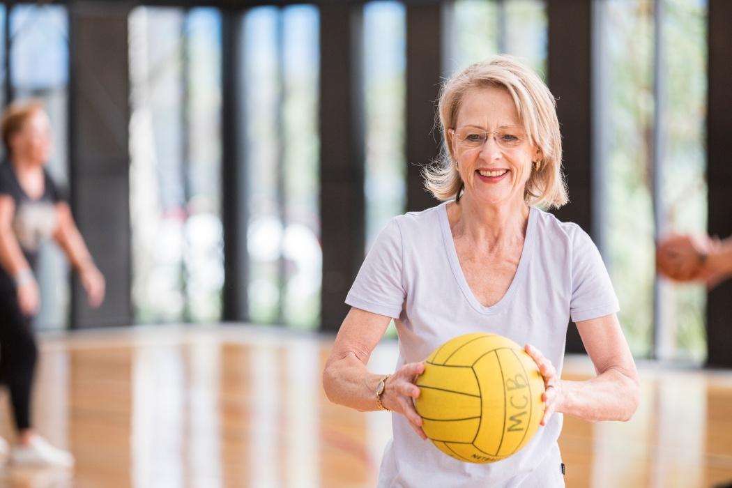 Woman holding yellow ball with MCB written on it
