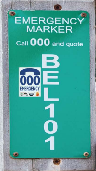 An emergency marker sign displaying the 000 emergency number and a code that reads "BEL101".